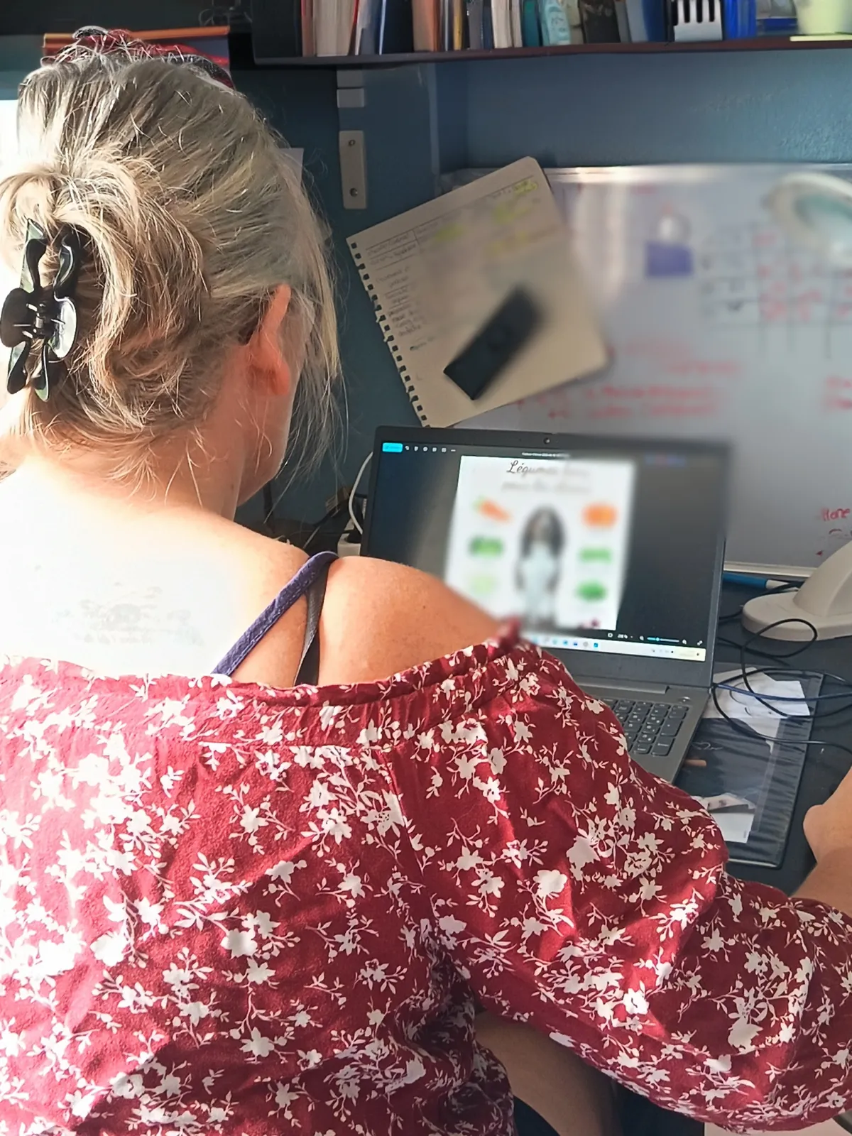 Jennifer De Groeve devant son ordinateur portable, en train de concevoir un support pédagogique illustré pour une séance de médiation animale